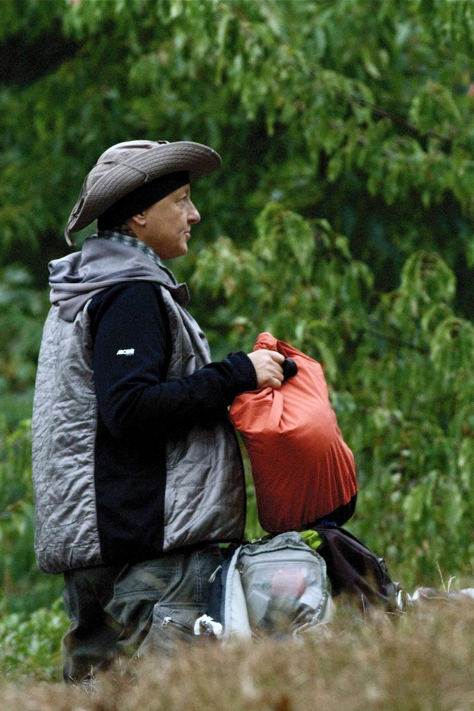Lee in a wide-brimmed hat packing up her bag in Central Park